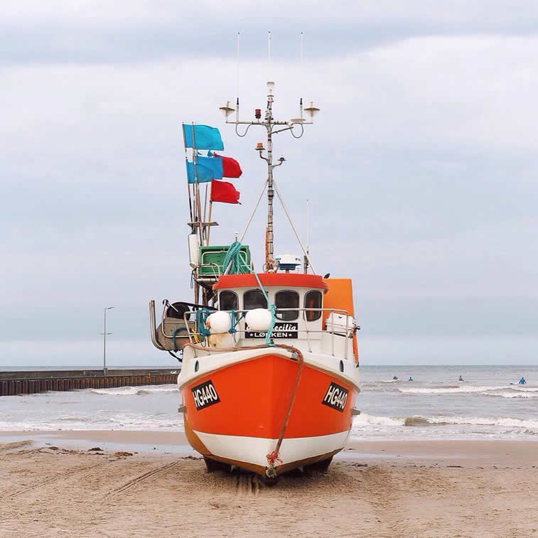 colorful ship on shore accidentally wes anderson