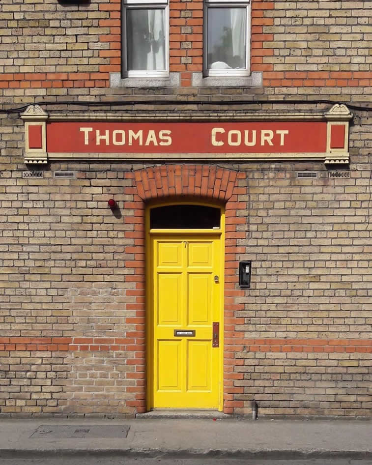 thomas court yellow doors brick building